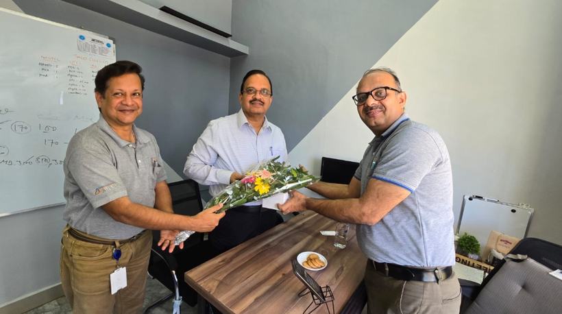 Dr Hegde being welcomed with a bouquet at an office