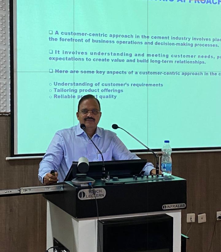 Dr Hegde at a lectern presenting on the customer-centric approach